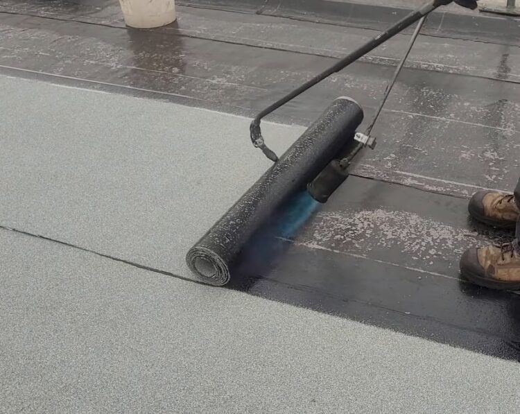 podgrzewanie papy termozgrzewalnej za pomocą palnika i klejenie jej do dachu